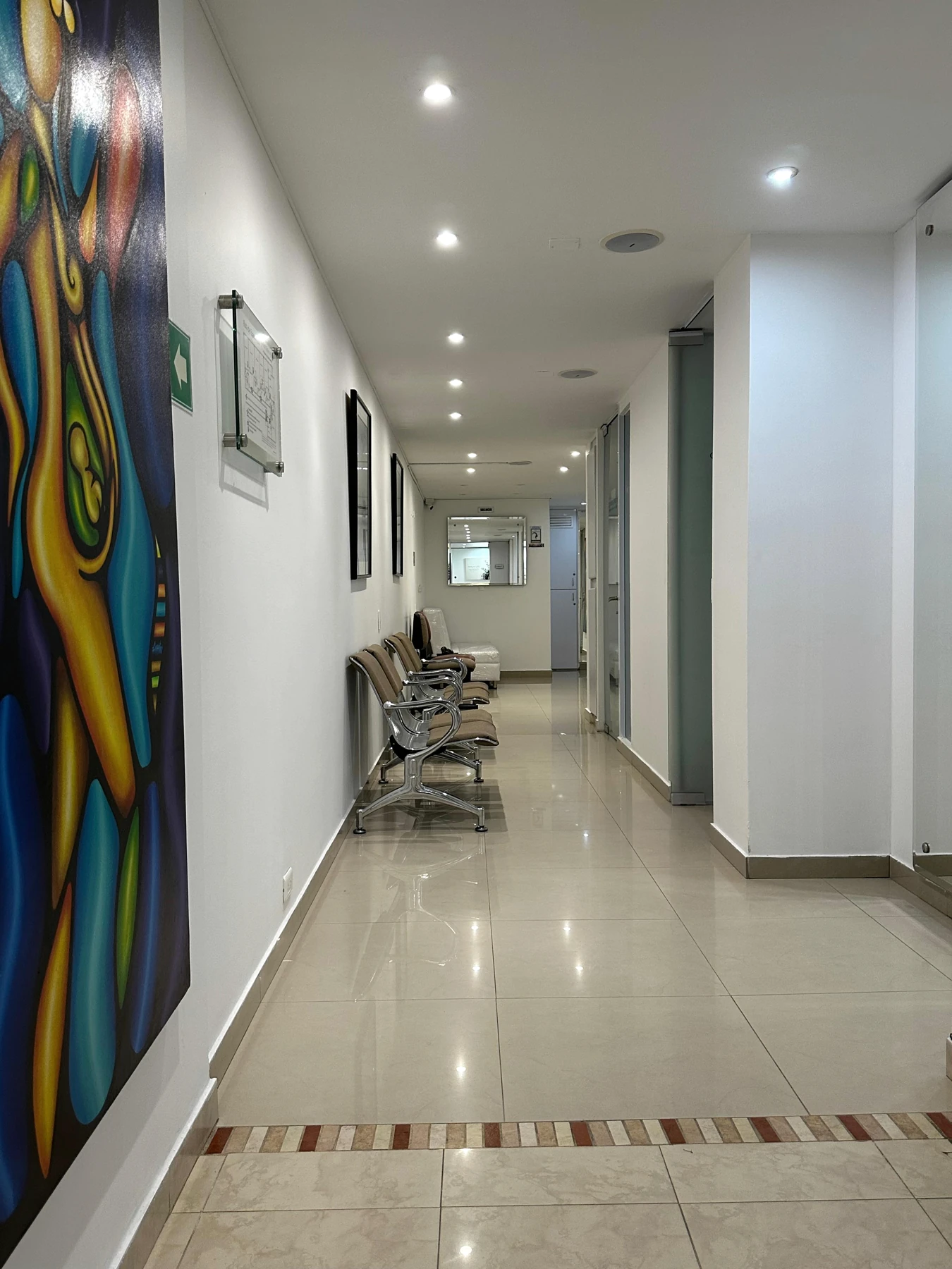 Sillas de espera y pintura de colores a lo largo del corredor de Medical Center 125.